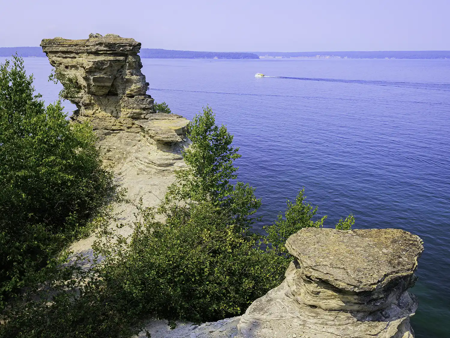 Kayakers gather under Miners Castle in Michigan's Upper Peninsula on a bright summer day